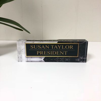 O laser preto da mesa cortou a placa de nome acrílica para a exposição da empresa